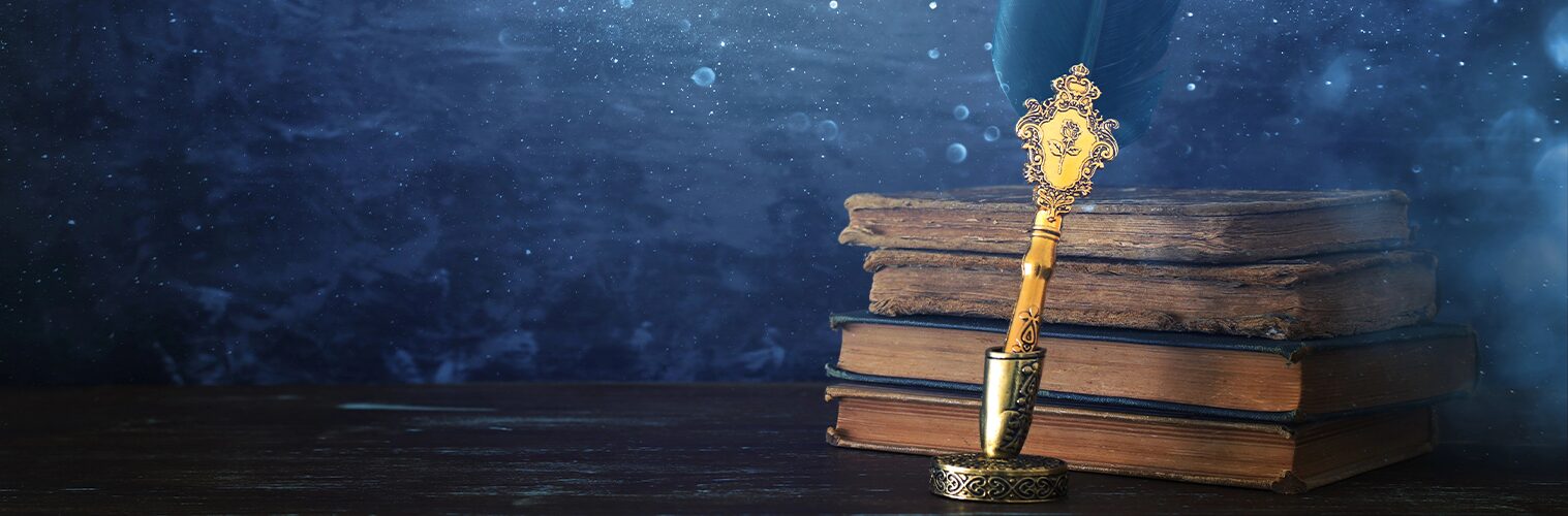 a stack of books and a fancy fountain pen on a sparkly background